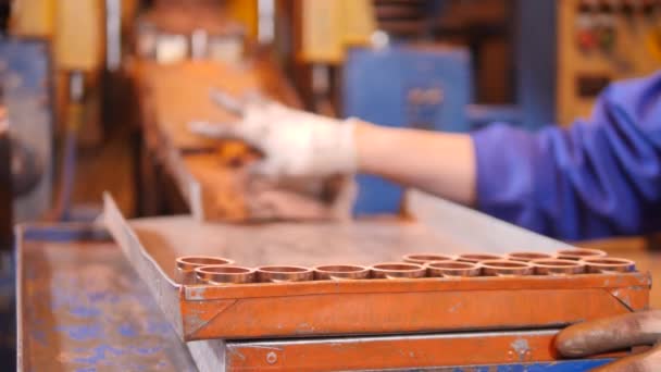 Trabajador de fábrica está recogiendo elementos de cobre liberados por un transportador — Vídeo de stock