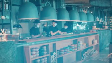 Bir grup aşçının tezgahta yemek yaptığı restoran.
