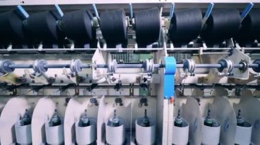 Dikiş makinesine iplik takılı dönen makaralar