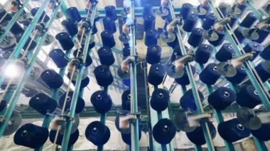 Endüstriyel dikiş sırasında birden fazla iplik makarası. Tekstil fabrikası üretim ekipmanları.
