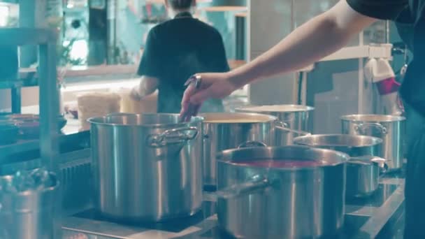 Ресторан повар перемешивает еду в горшках — стоковое видео