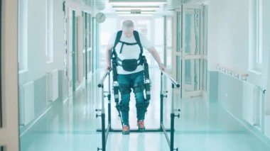 Bir adam hastanede yürümek için egzosuit kullanıyor.