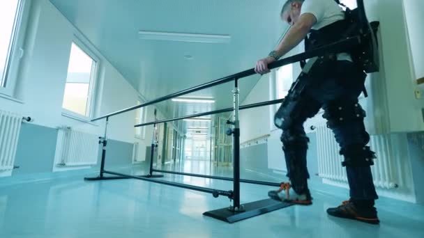 Un hombre está usando exoesqueleto mientras aprende a caminar — Vídeo de stock