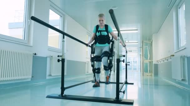 Mujer joven con discapacidad está aprendiendo a caminar en el exoesqueleto — Vídeos de Stock