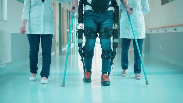 Salle d'hôpital avec travailleurs médicaux et un patient en exosquelette — Video