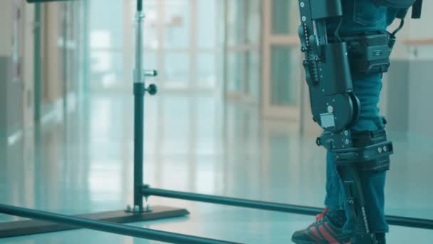 Mužský pacient se snaží chodit v exoskeletonu — Stock video