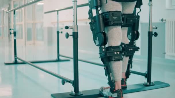 Pacient v exoskeletonu se učí chodit po nemocnici. — Stock video