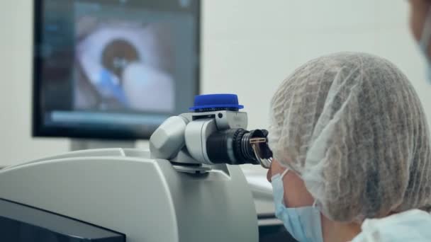 Οφθαλμίατρος παρατηρεί λειτουργία των ματιών μέσω μικροσκοπίου — Αρχείο Βίντεο