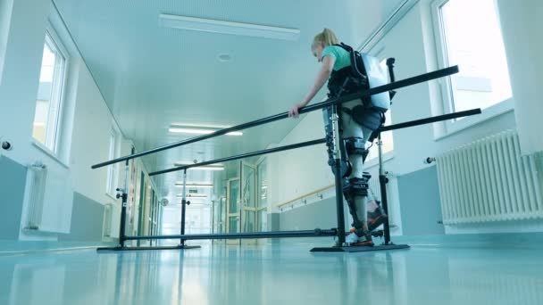 Žena se zdravotním postižením používá exoskeleton k procvičování chůze — Stock video