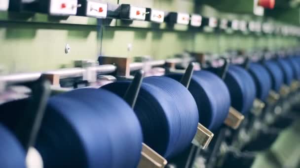 Несколько катушек с цветными нитями во время механического шитья. Оборудование для текстильной промышленности. — стоковое видео