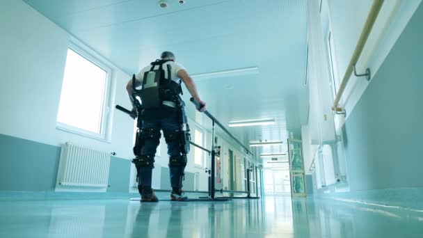 Hombre discapacitado está caminando en el exoesqueleto en un hospital — Vídeos de Stock