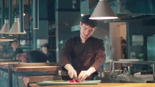 Erkek aşçı sebze keserken gülümsüyor — Stok video