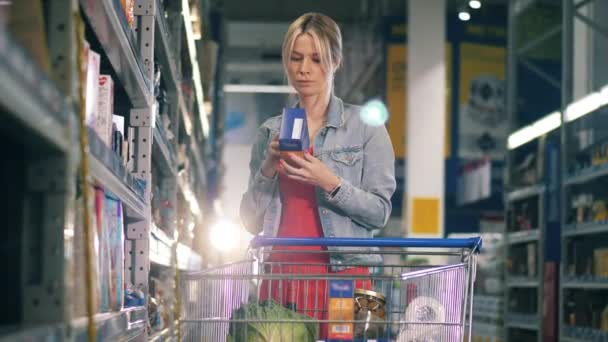 Женщина выбирает пакеты зерна во время шоппинга — стоковое видео
