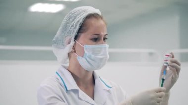 Kadın bir doktor şırıngayı ilaçla dolduruyor.