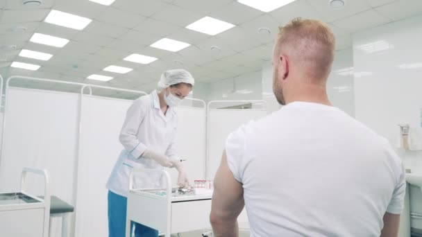 医者にワクチンを接種された男と病院の部屋 — ストック動画