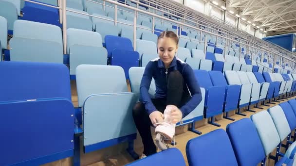 A női műkorcsolyázó befűzi a korcsolyákat. — Stock videók