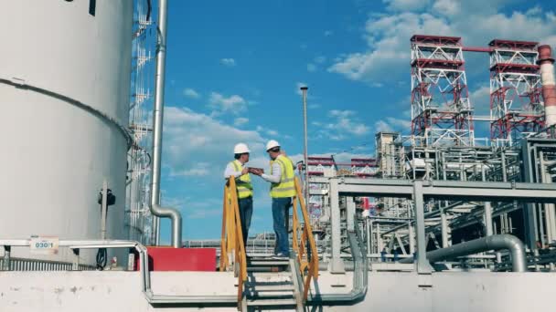 Trabajadores de refinerías de petróleo están hablando de un proyecto — Vídeo de stock