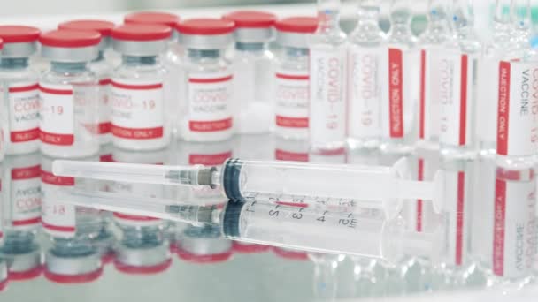 Koronavírus elleni vakcinák és egy fecskendő közelről — Stock videók