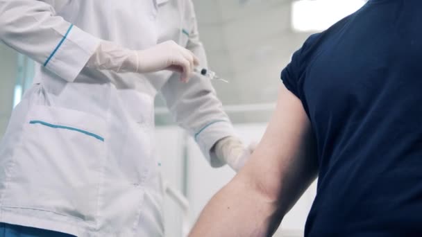 Le médecin injecte le vaccin dans le bras des patients — Video