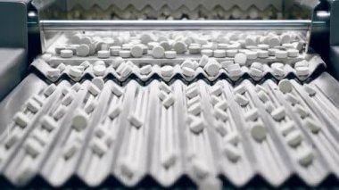 Tabletler basamaklı fabrika taşıyıcısı boyunca ilerliyor.