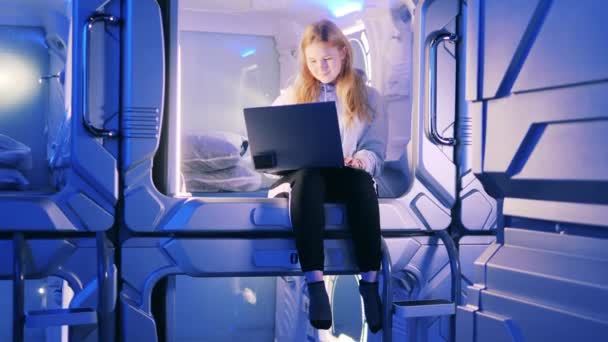 Ragazza adolescente con un computer portatile in una delle camere d'albergo pod — Video Stock