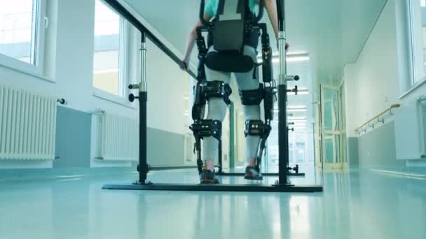 Handikappade kvinna går i exoskelettet själv — Stockvideo