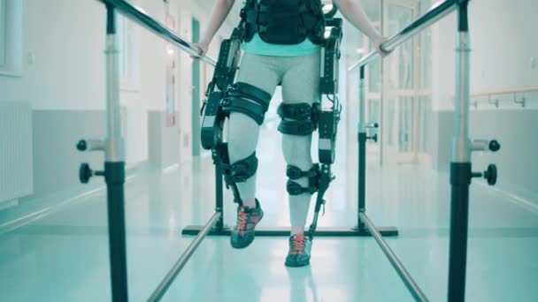 Mujer discapacitada está usando exoesqueleto durante la fisioterapia — Vídeo de stock