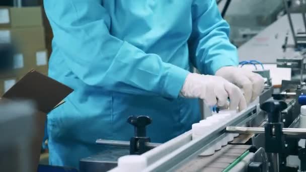 Fabriek werknemer is het inpakken van pil potten in een doos — Stockvideo
