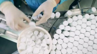 Fabrika çalışanı ilaç şişelerini kapatıp yerlerini değiştiriyor.