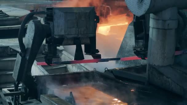 Industriemaschinen transportieren Metallplatten in heißes Wasser — Stockvideo