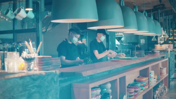 Chefs in face masks are cooking in the open restaurant kitchen — Stock Video