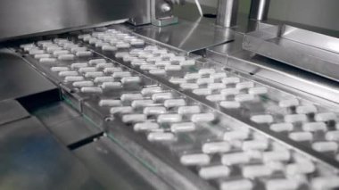 Kapsül ilaçları bir taşıyıcı tarafından taşınıyor.