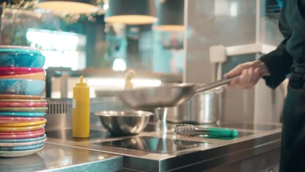 Jedzenie na patelni jest wyrzucane przez kucharza — Wideo stockowe