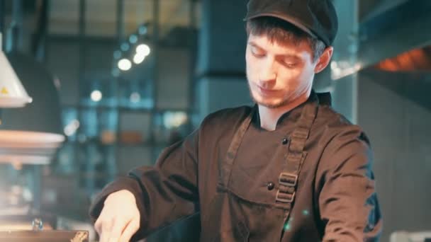 Чоловічий шеф-кухар нарізає картоплю на дошці — стокове відео