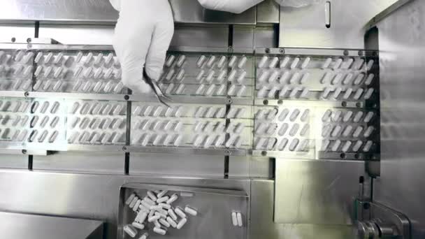 Fabriek werknemer vervangt een aantal van de pillen op de transportband — Stockvideo