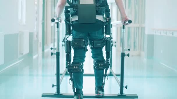 남자 환자는 외골격을 사용하여 걷는 법을 배우고 있다 — 비디오