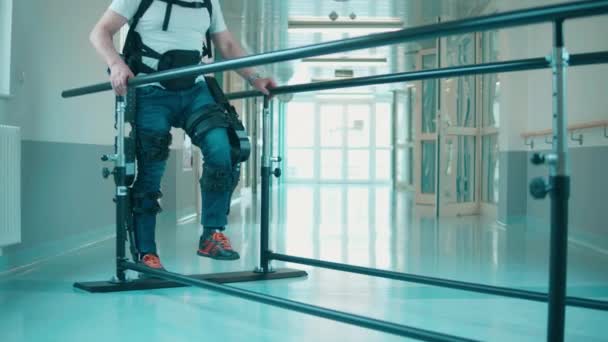 Hombre discapacitado está haciendo fisioterapia en el exoesqueleto — Vídeo de stock