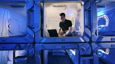 Adamın biri bilgisayarını bir otelin misafir odasında kullanıyor.