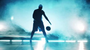 Duman dolu bir oda ve içinde basketbol oynayan bir adam.