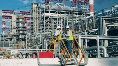 Petrol rafinerisi çalışanları fabrika inşaatlarını tartışıyorlar.