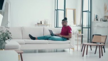 Genç Afro-Amerikalı adam evde bir e-ders veriyor.