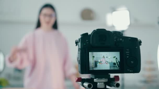 Video camera tijdens het filmen van een vlog van een vrouw koken — Stockvideo