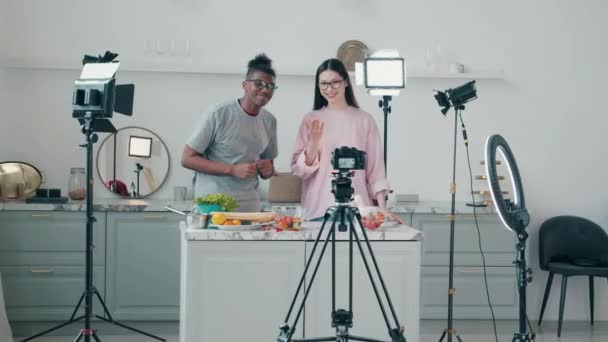Пара молодых людей снимают кулинарный видеоблог вместе — стоковое видео