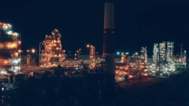 Gece lambalarıyla aydınlatılmış petrol rafinerisi.