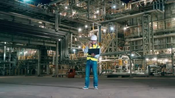 Experto masculino está utilizando un ordenador portátil en las instalaciones de la planta de refinería — Vídeos de Stock