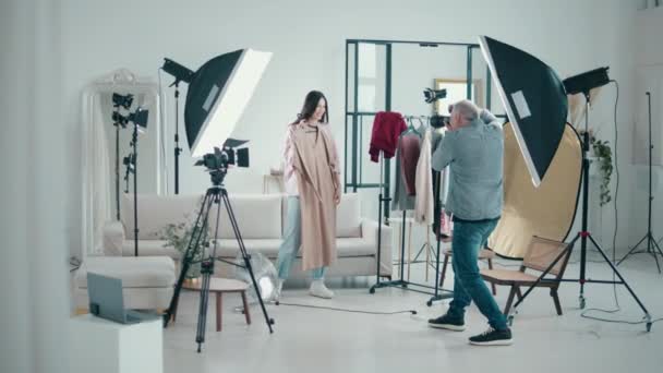 Lady model is being photographed with clothes in a studio — Stock Video