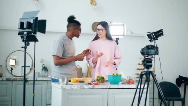 Cheerful young people are shooting a vlog in a studio kitchen — Stock Video