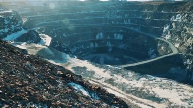 Güneş ışığında biraz kar olan devasa bir maden ocağı.