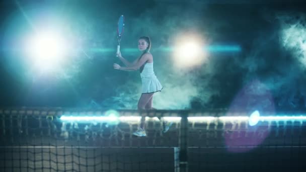 Atleta femenina devuelve una pelota de tenis en cámara lenta — Vídeo de stock