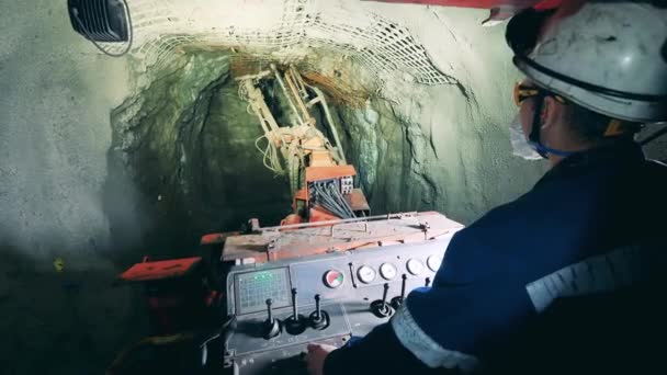 Mineiro está operando uma máquina de irrigação dentro da mina — Vídeo de Stock